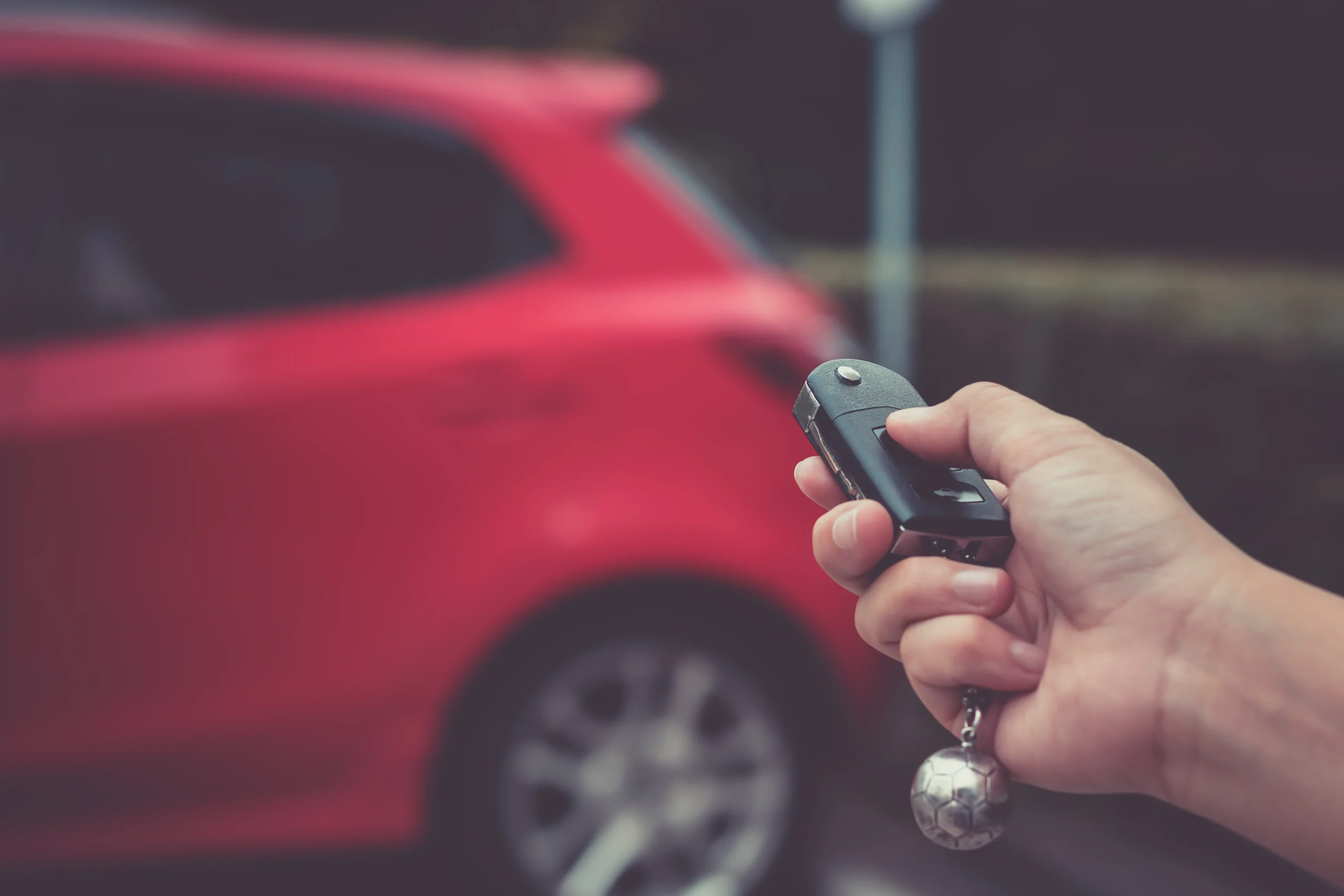 Human hand pushing button on remote control car key